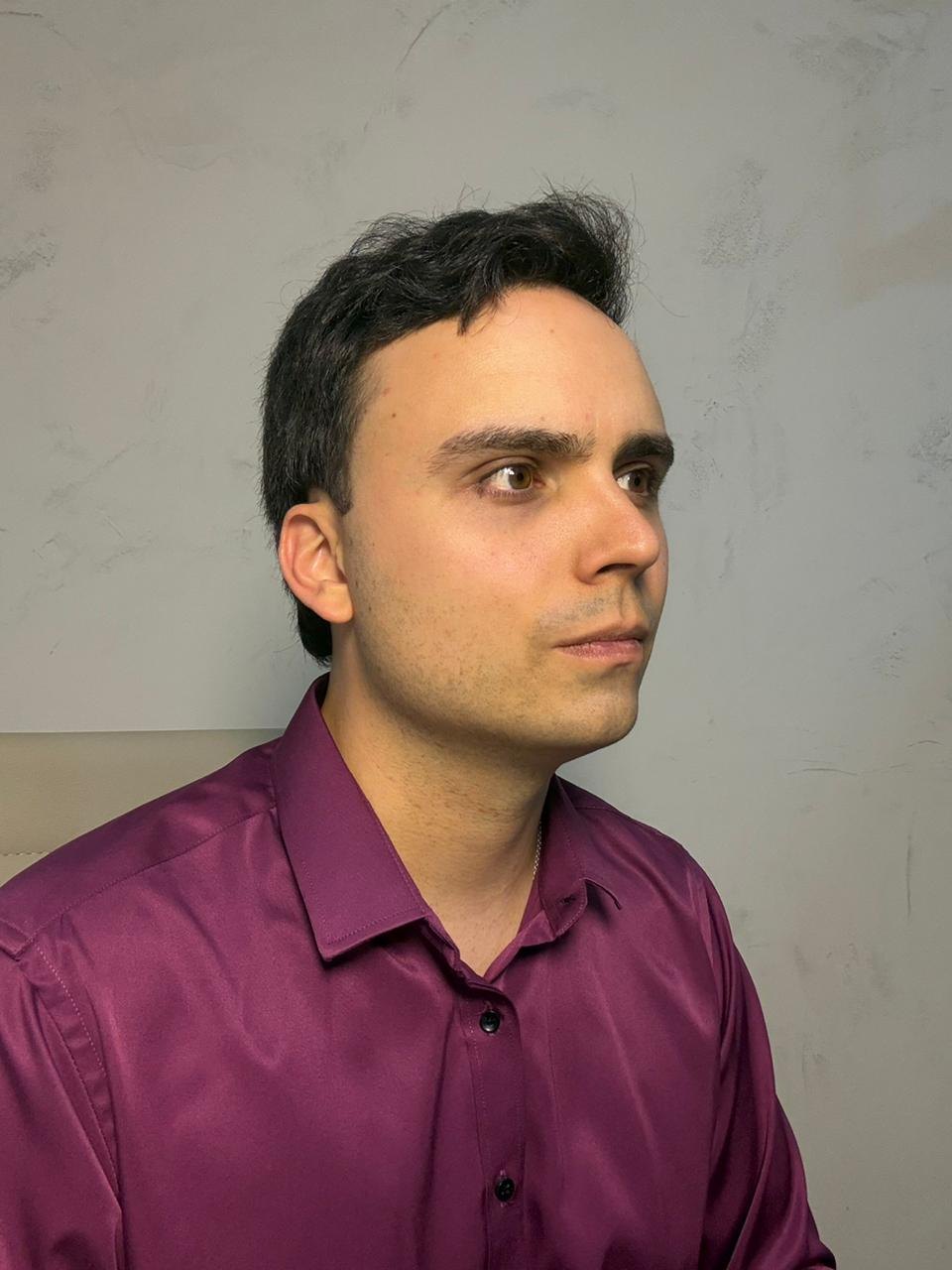 Dr. Lucas Batistuzzo de perfil, olhando para o lado