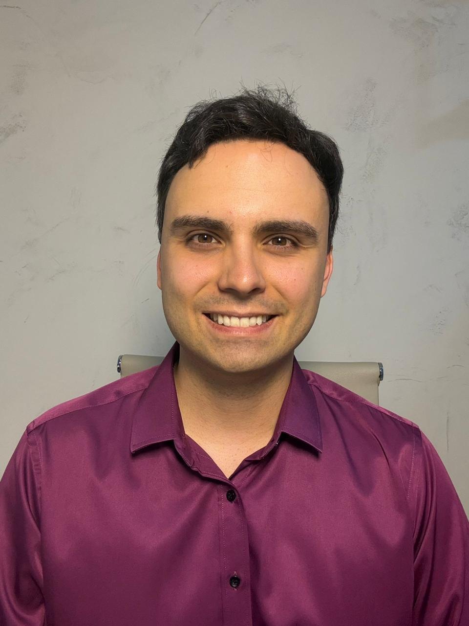 Dr. Lucas Batistuzzo sorrindo, de frente para a câmera